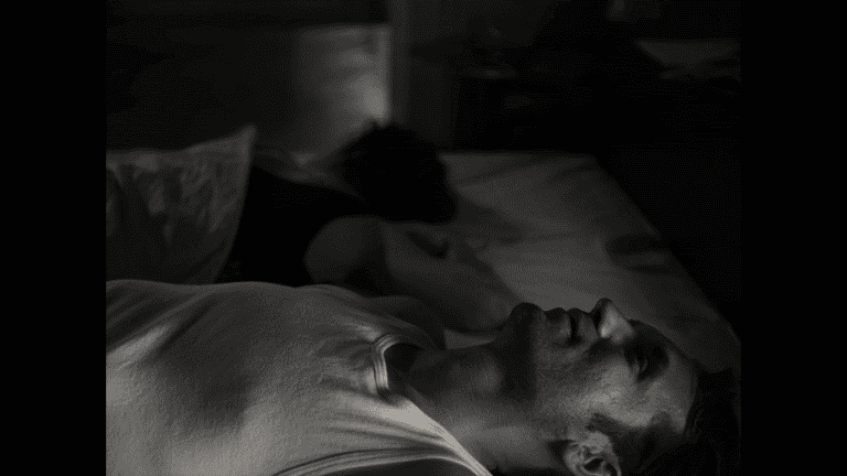 a man and woman lying on a bed